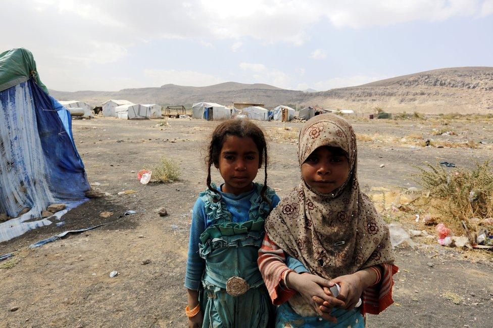 Two sisters in the camp stare into the camera