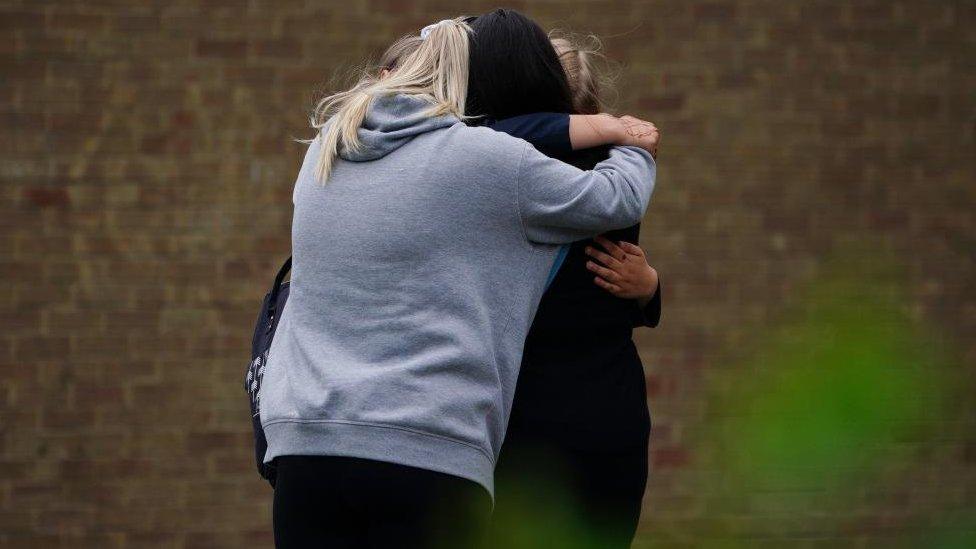 Parents hugging outside school