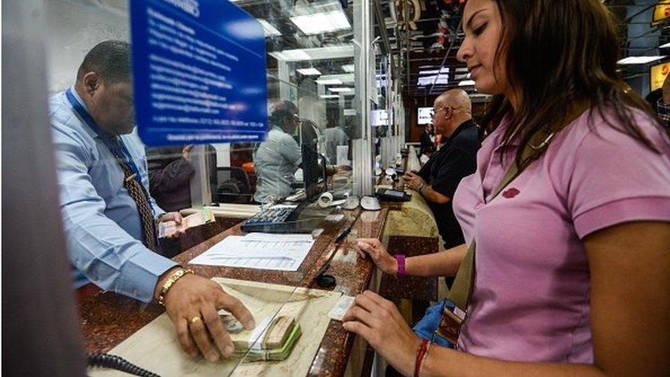 People queue at a currency exchange office in Caracas on 19 February, 2015.