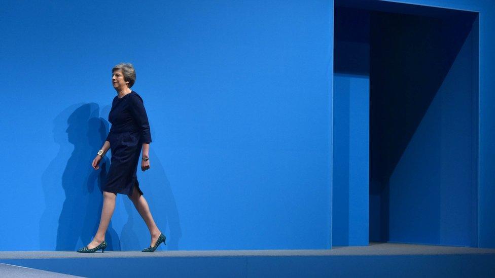 Theresa May walks onto the conference stage