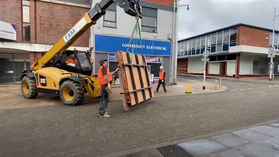 Banksy being removed from the side of an empty shop in Lowestoft