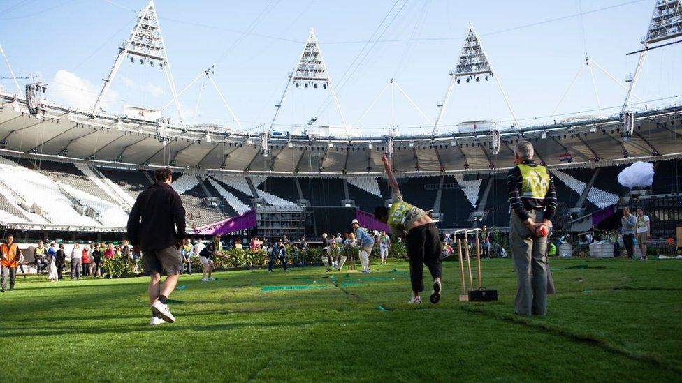 People playing cricket in stadium