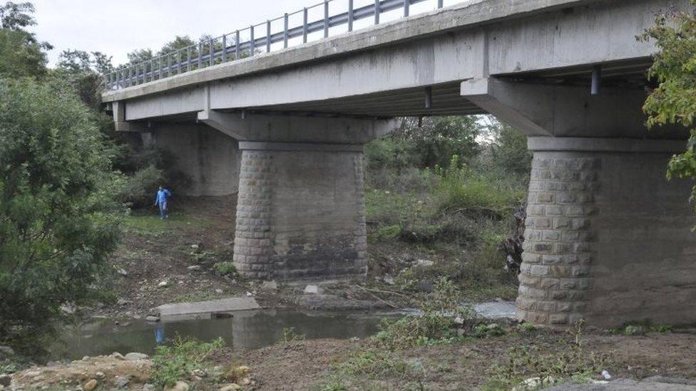 A television cameraman walks at the site where a man travelling with a large group of refugees from Afghanistan was shot by a border police officer