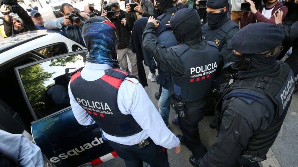 Spanish police put one of the nine detained suspects in a police car in Barcelona. Photo: 25 April 2017