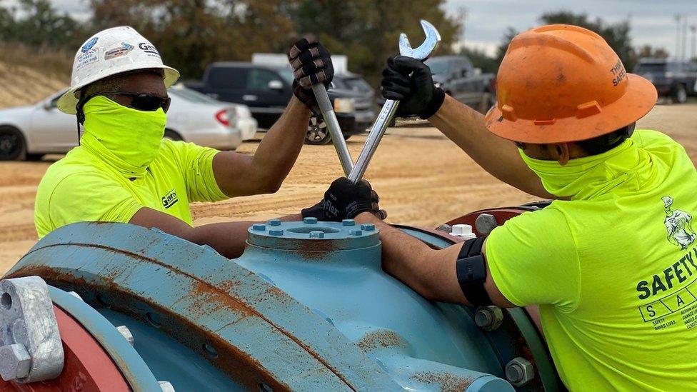 Construction workers testing Kenzen body temperature monitoring devices attached to their arms