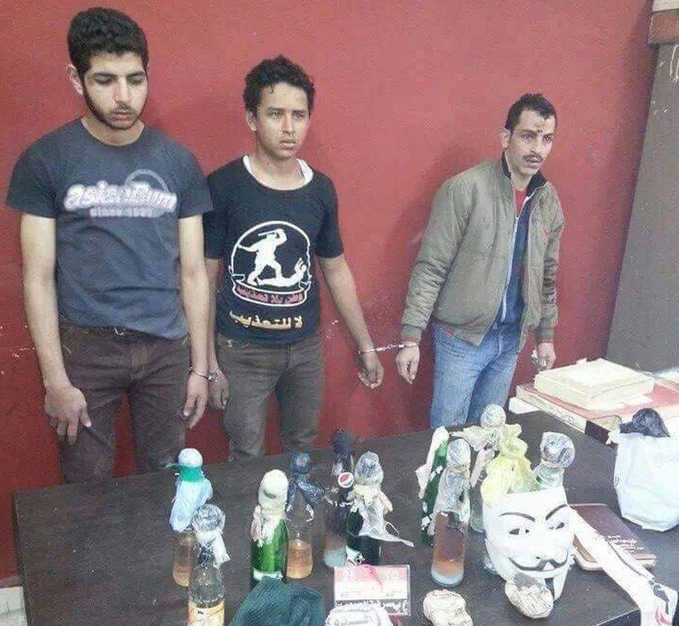 Mahmoud Mohammed Hussein (centre) at the time of his arrest in January 2014, handcuffed to another detainee and wearing a T-shirt saying: "A nation without torture"