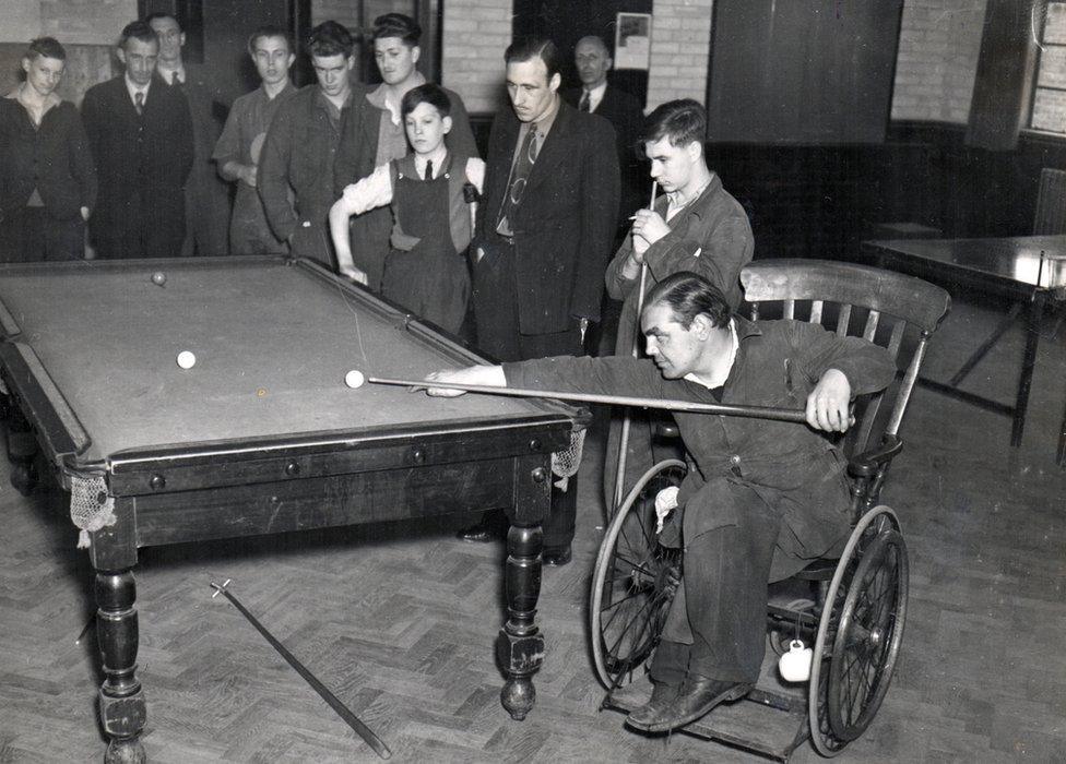 A wheelchair user playing pool 1940s