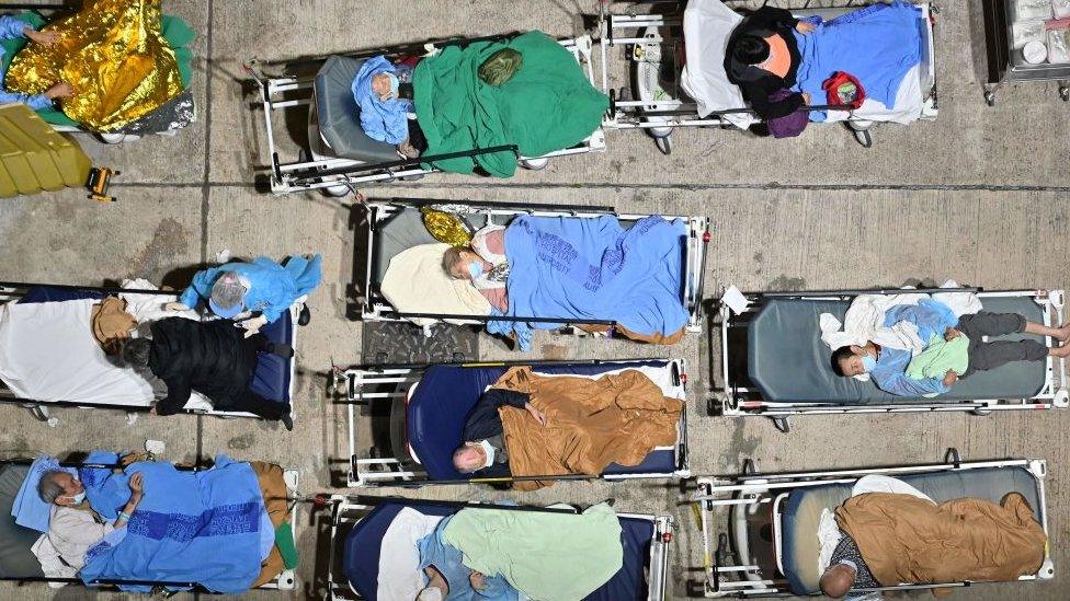 People sleep in hospital beds with temperatures falling at nighttime outside the Caritas Medical Centre in Hong Kong on February 16, 2022,