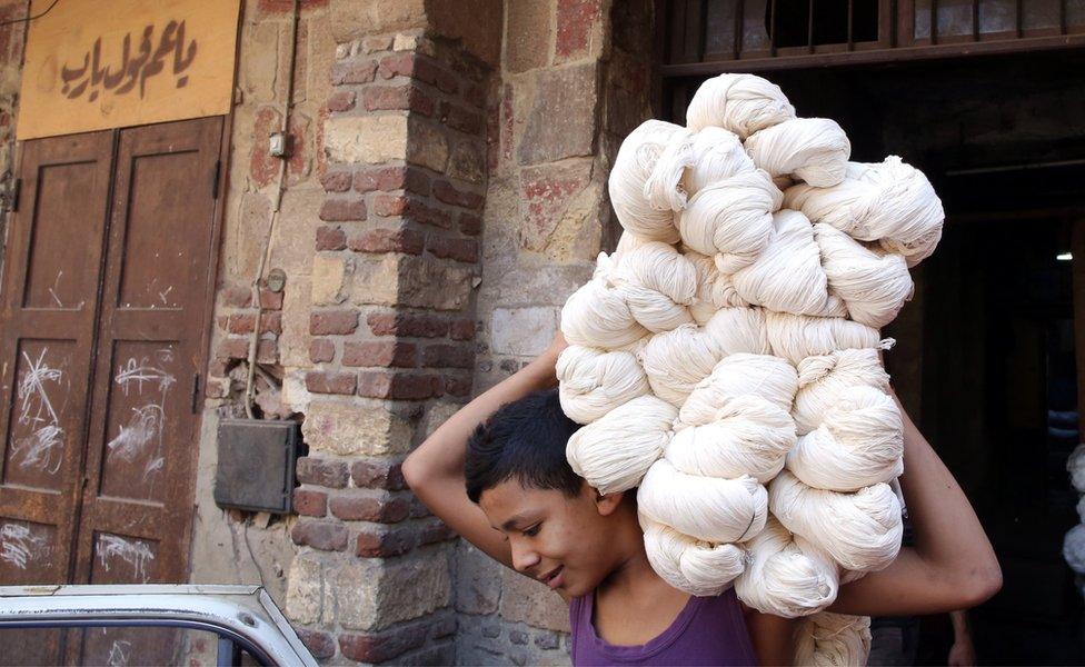 Moustafa, 15, carries white yarn rolls at Salama"s tannery in Cairo, Egypt, 07 November 2017. Salama started working when he was seven years old during the reign of King Farouk over Egypt because, according to him, the police used to arrest unemployed males of all ages. Now, after almost 70 years, Salama"s tannery is the only one left in the old part of Cairo. The yarn produced is used for shoe laces, mattresses upholstery, ballet dance outfits,