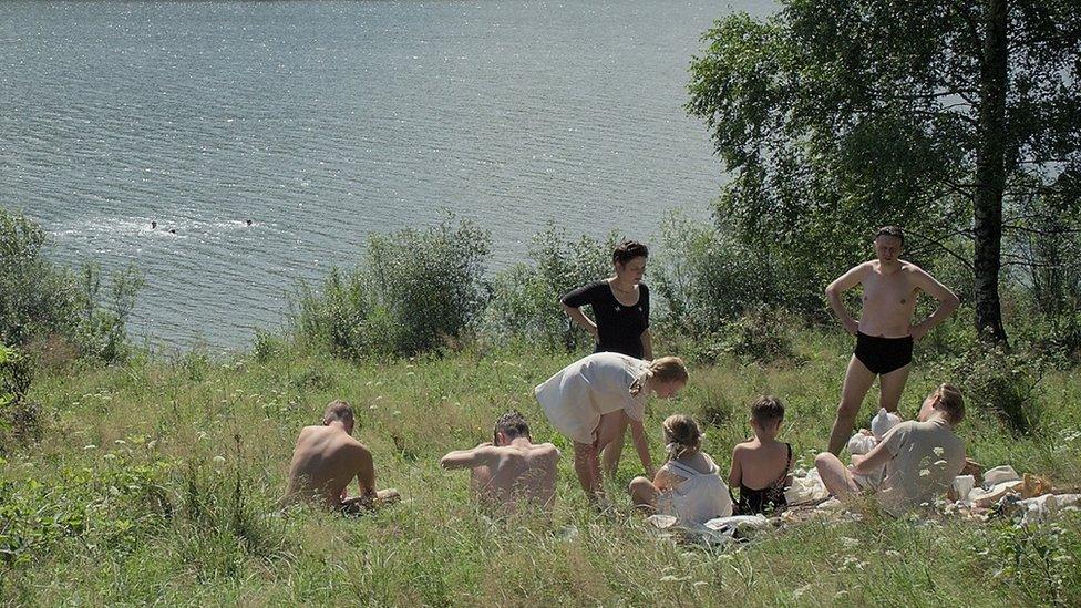 A family having a riverside picnic in The Zone of Interest