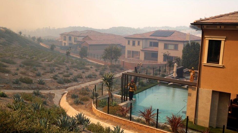 Firefighters check the area as the Silverado Fire is approaching, near Irvine, California