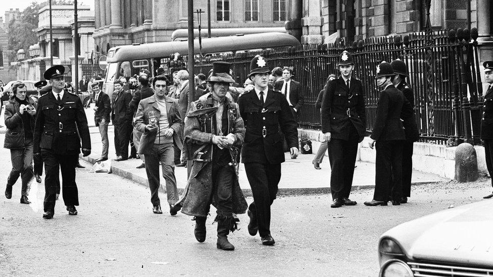 Police lead away a squatter