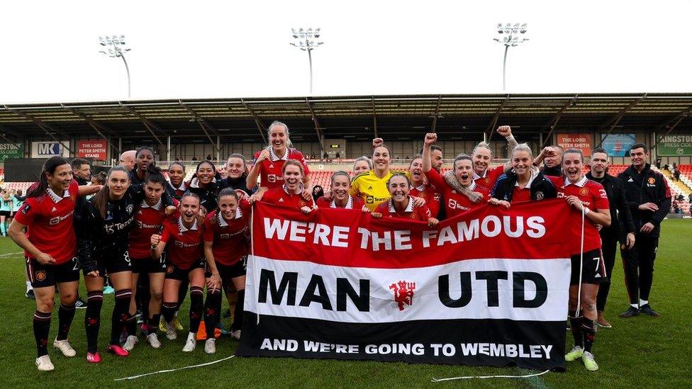 Manchester United players hold a banner reading 'We're the famous Man Utd and we're going to Wembley'