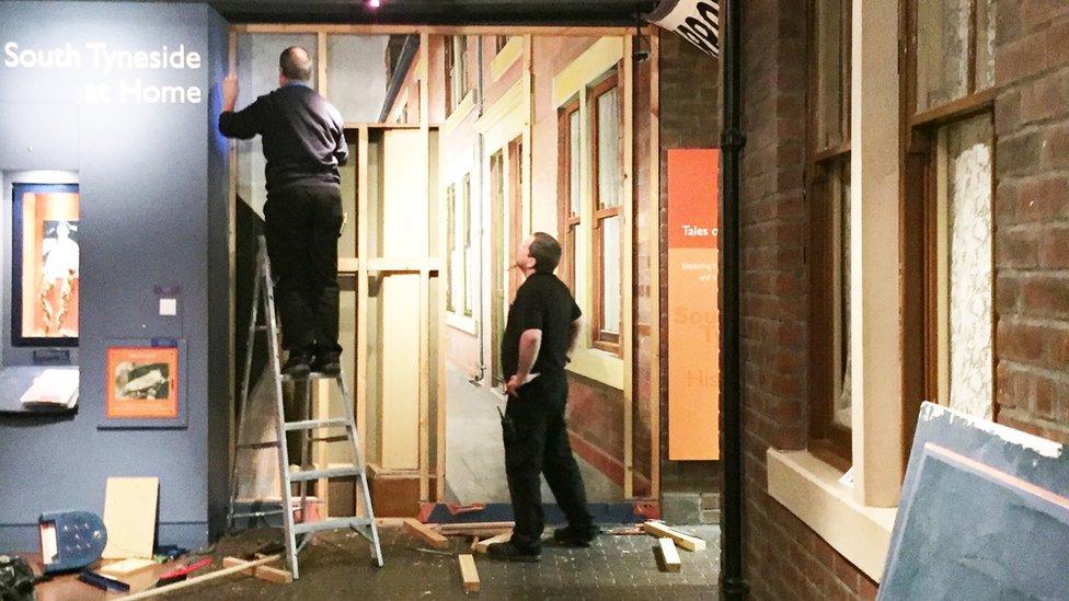 Removing the boards covering the Jarrow March mural