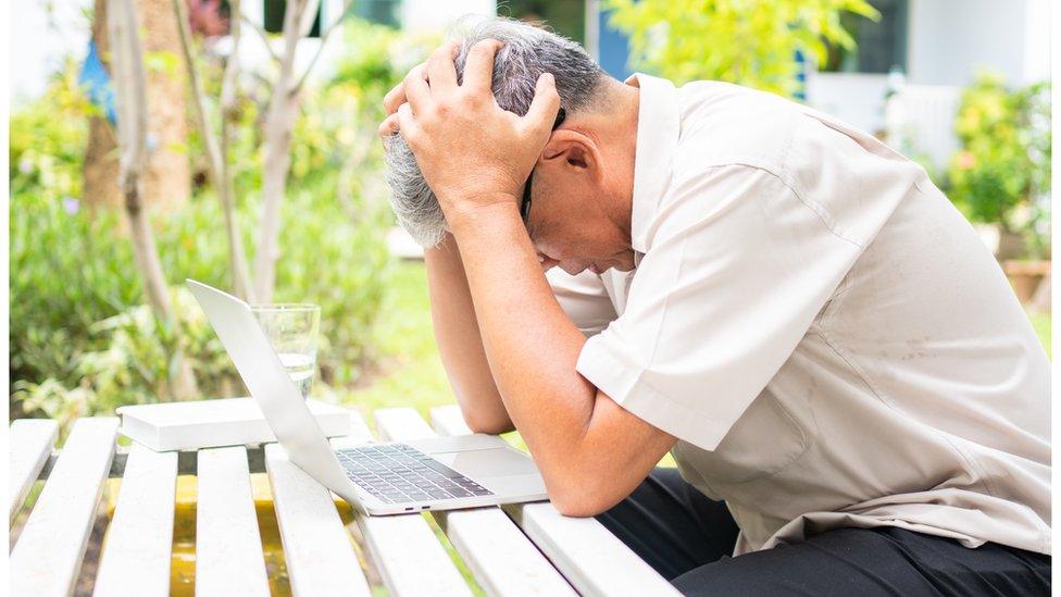 Older man struggling with using computer