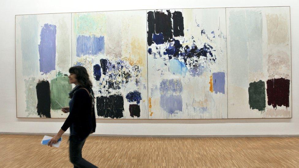 Visitor walking past a Joan Mitchell artwork