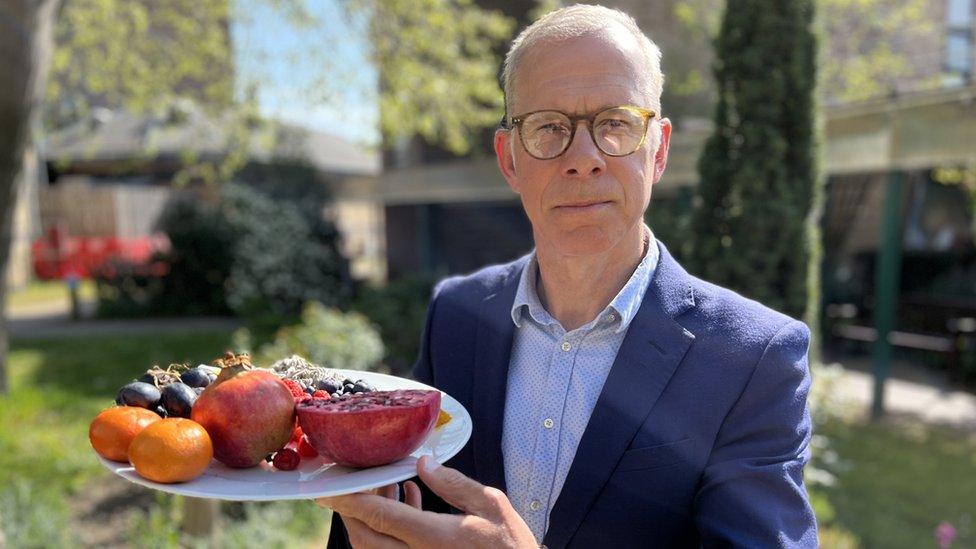 Prof Robert Thomas, who led a long Covid treatment trial, holds a plate of phytochemical-rich foods including citrus fruits and grapes