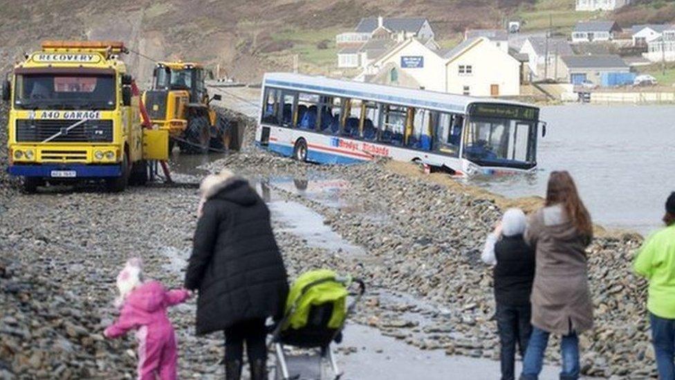 Onlookers watched as the stranded bus was moved on Sunday