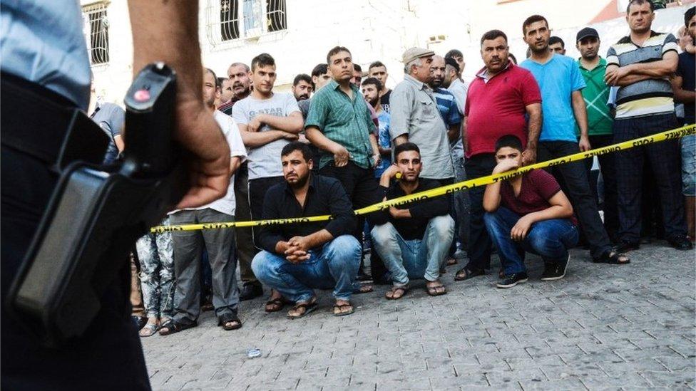 People stand behind the police cordon near the scene of Saturday's blast (21/08/2016)