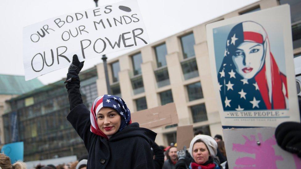 A Woman wearing a USA flag as a headscarf attends a protest for women's rights and freedom in solidarity with the Women's March on Washington in front of Brandenburger Tor on January 21, 2017 in Berlin, Germany.