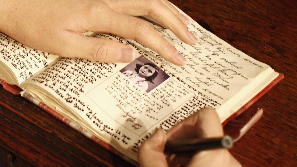 model of Anne Frank writing her diary