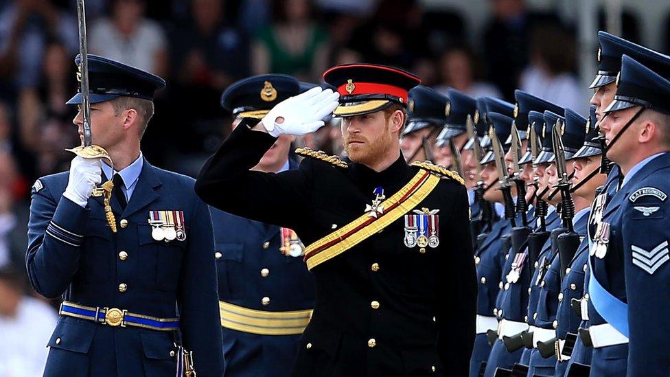 Prince Harry saluting in royal uniform.