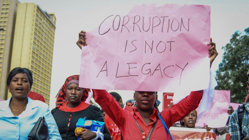 A protestor carries a placard as Kenyans protested in the streets