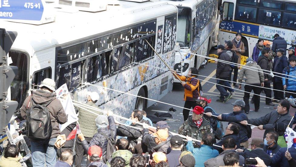 Supporters of impeached South Korean President Park Geun-hye clash with police as they attempt to pass a barricade of police buses near the Constitutional Court in Seoul, 10 March 2017