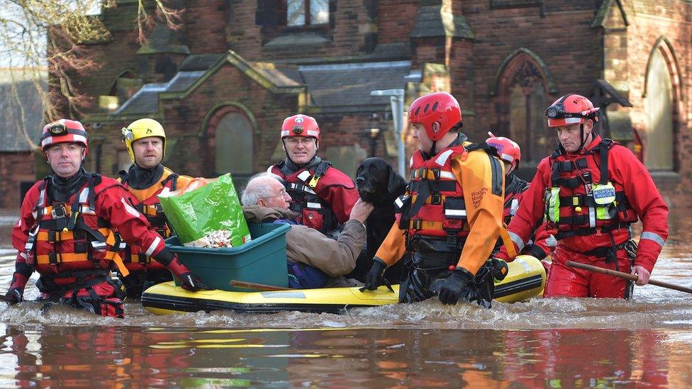 A man and his dog are carried to safety in Carlisle on board a small vessel