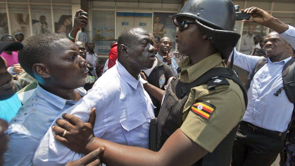 Opposition leader and presidential candidate Kizza Besigye, center, is grabbed by riot police after attempting to walk with his supporters along a street in downtown Kampala, Uganda Monday, Feb. 15, 2016.