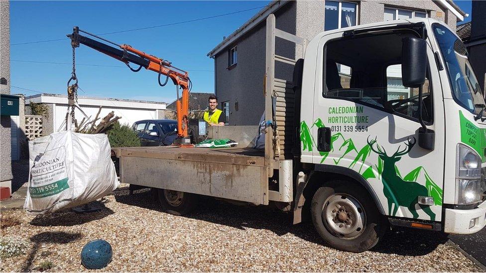 Low-loader picking up waste