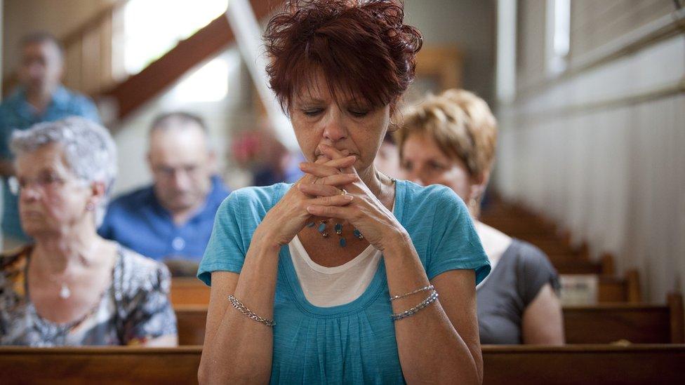 A woman attends Mass in 2013 to pray for the Lac-Megantic victims