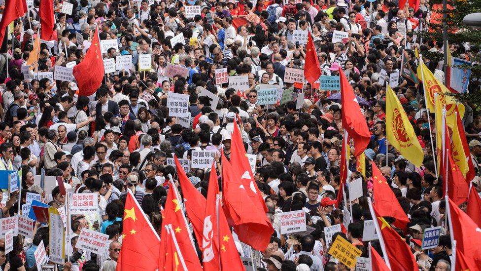 Pro-Beijing demonstrators shout slogans and wave flags outside the Hong Kong Legislative Council on November 13, 2016