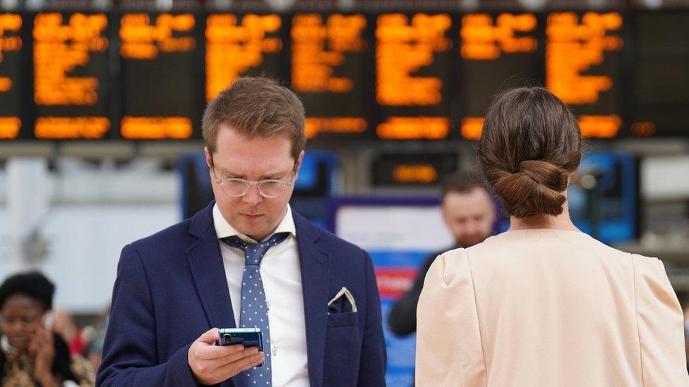 Passengers wait on the concourse at Paddington train station in London during a 24-hour strike by four unions