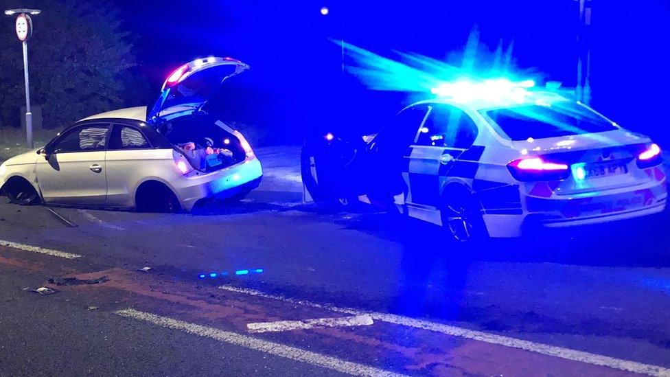 The damaged police car and Audi