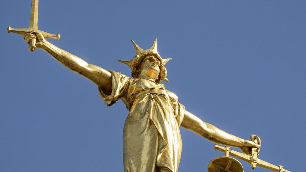 Close-up of the statue of Lady Justice, holding a sword and the scales of justice, located on top of the dome above the Old Bailey (Central Criminal Court) in London. Lady Justice is based on Justitia, the Roman goddess of justice.