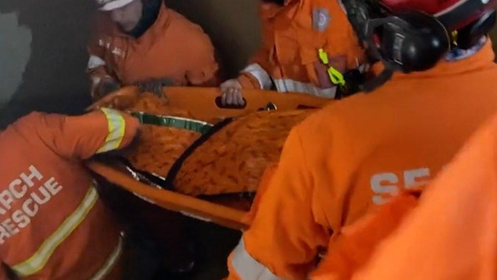 Woman being carried down stairs on a stretcher