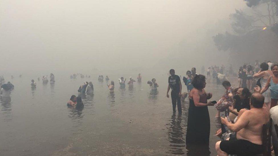 People on the coast in Greece to escape the fire