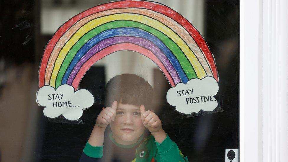 A rainbow drawing is seen as Jake Weller looks through the window of his house as the spread of the coronavirus disease (COVID-19) continues, Aylesbury, Britain