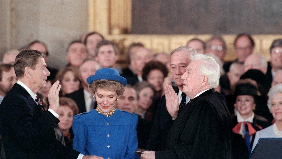 US President Ronald Reagan (C) is sworn in as 40th President of the United States by Chief Justice Warren Burger (R) beside his wife Nancy Reagan (C) during inaugural ceremony, on January 21, 1985