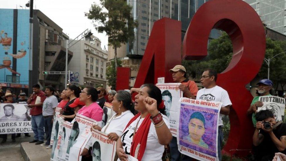 Relatives pose with images of some of the 43 missing Ayotzinapa College Raul Isidro Burgos students in front of a monument of the number 43, during a march to mark the 41st month since their disappearance in the state of Guerrero, in Mexico City, Mexico February 26, 2018