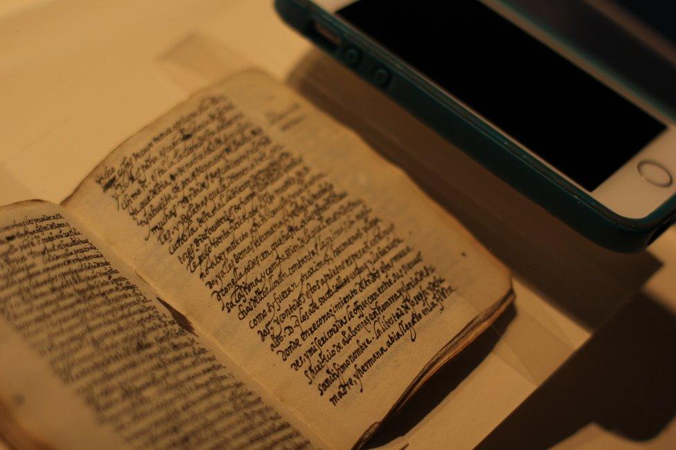 An iPhone lies next to the manuscript