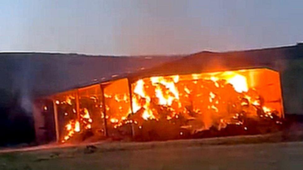 A large roadside barn alight.