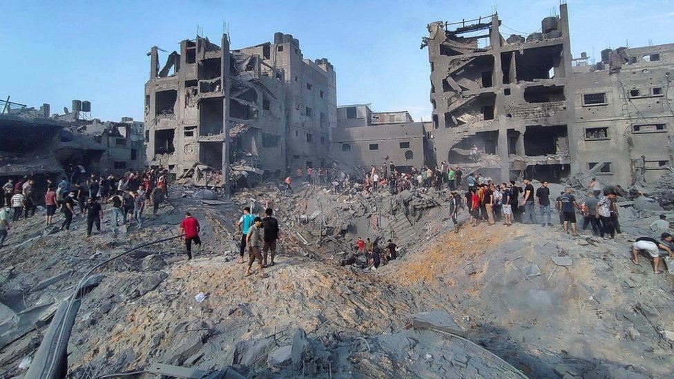 Palestinians search for casualties at the site of Israeli strikes on houses in Jabalia refugee camp in the northern Gaza Strip