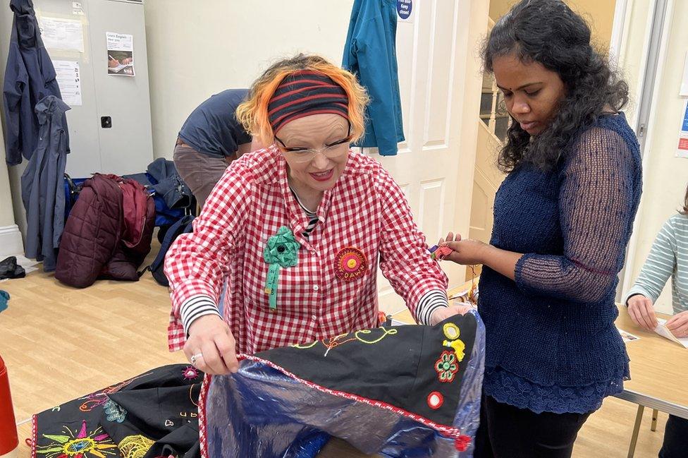 two women looking at some stitching