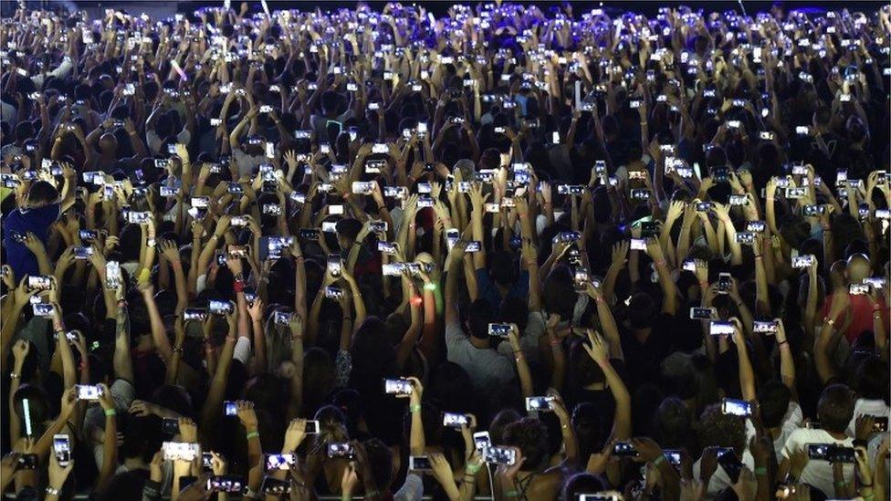 Fans use their phones at concert