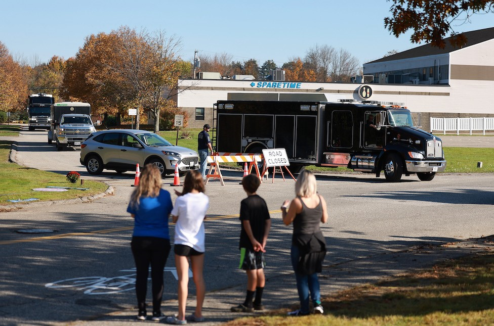 Locals watch police leave the site of one of the shootings