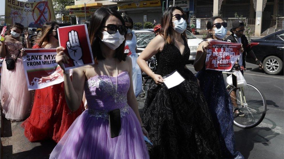 Women dressed in ball gowns hold up placards as they march during a protest against the military coup, in Yangon, Myanmar, 10 February 2021.