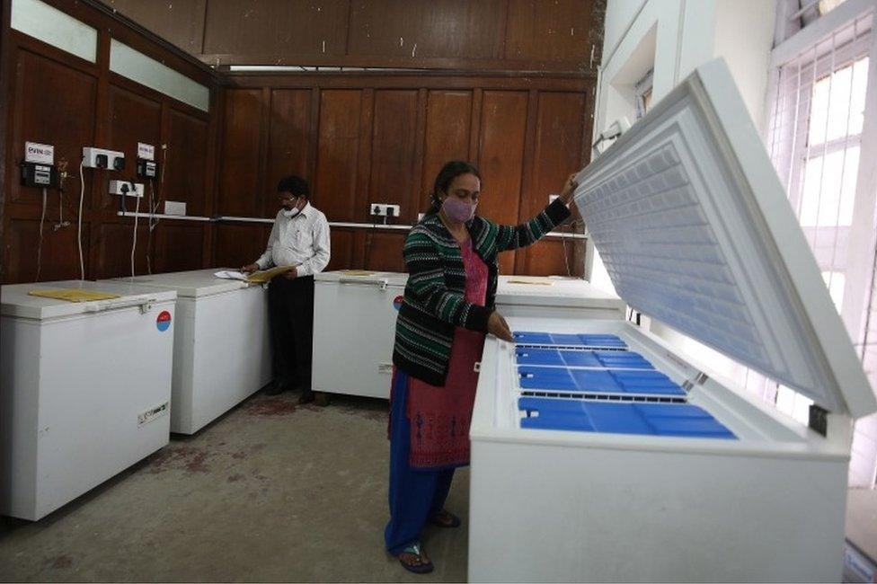 An Indian health official conducts routine checks of the Electronic Vaccine Intelligence Network (EVIN) ice line cold storage refrigerator at a city government hospital in Bangalore, India.