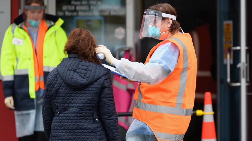 Medical worker carrying out a temperature check outside a medical centre